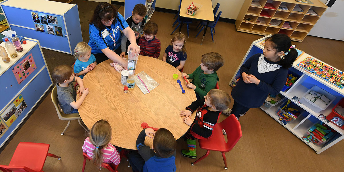 Children sitting around a table at a child-care facility.